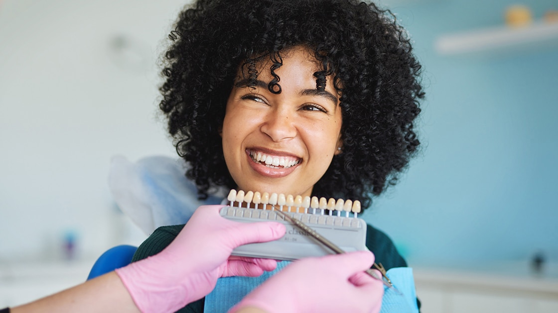 Smiling Woman At Dentist with Shade Color Chart