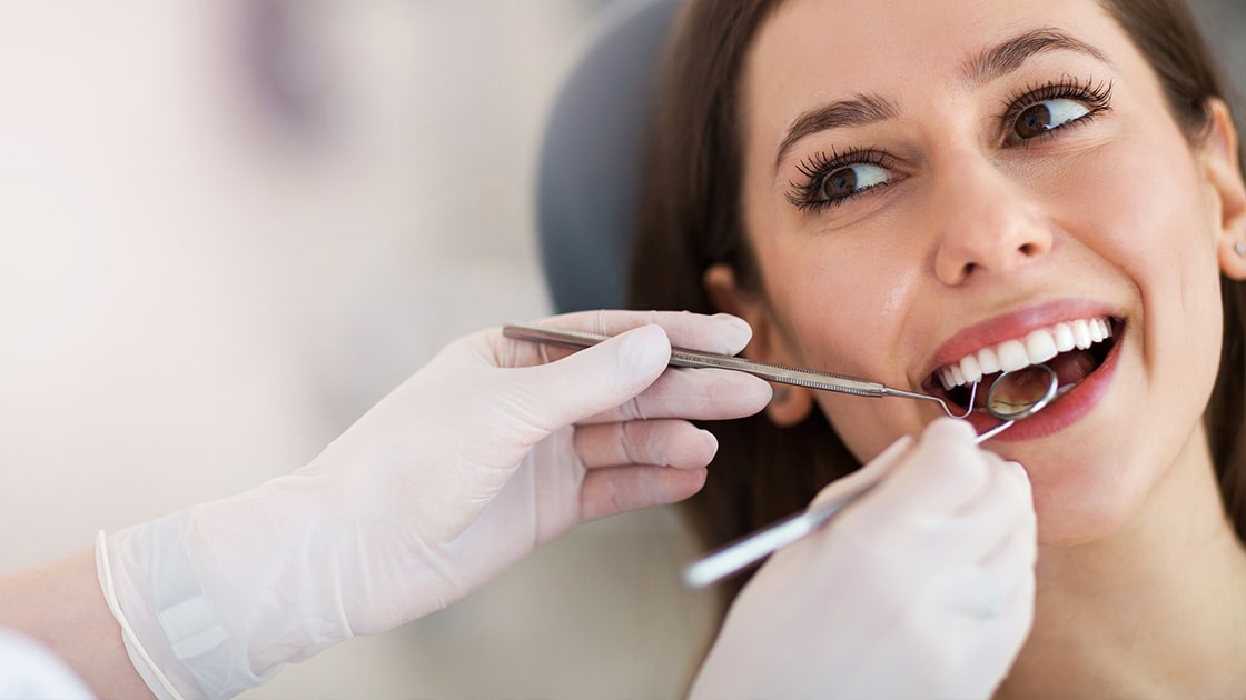 Smiling Woman Receiving Dental Exam