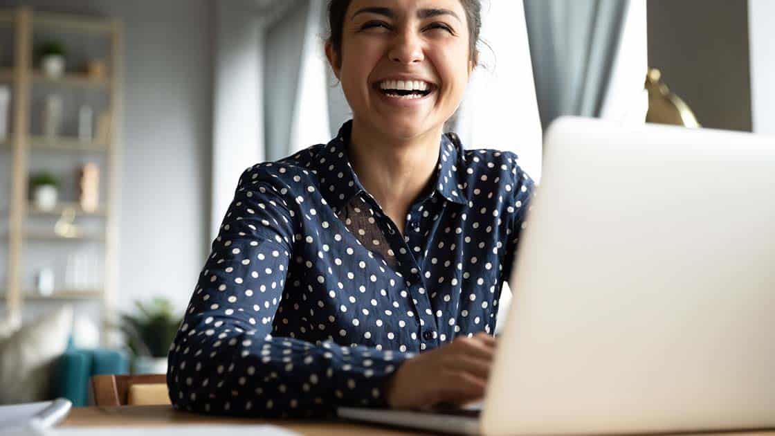 woman laughing on laptop